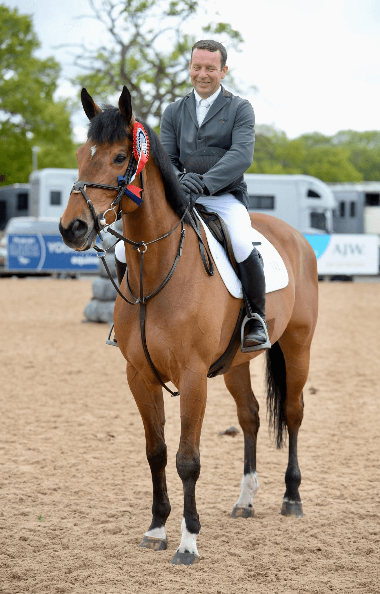 Alistair Gatherum on a bay horse in an outdoor arena.